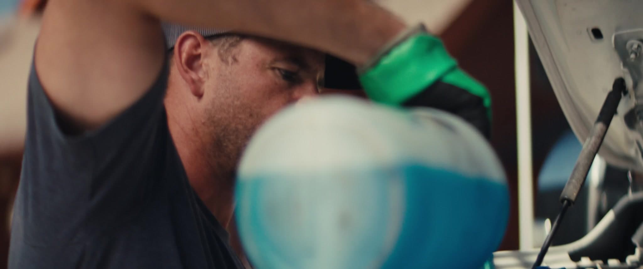 A focused MAXI technician performing an oil change