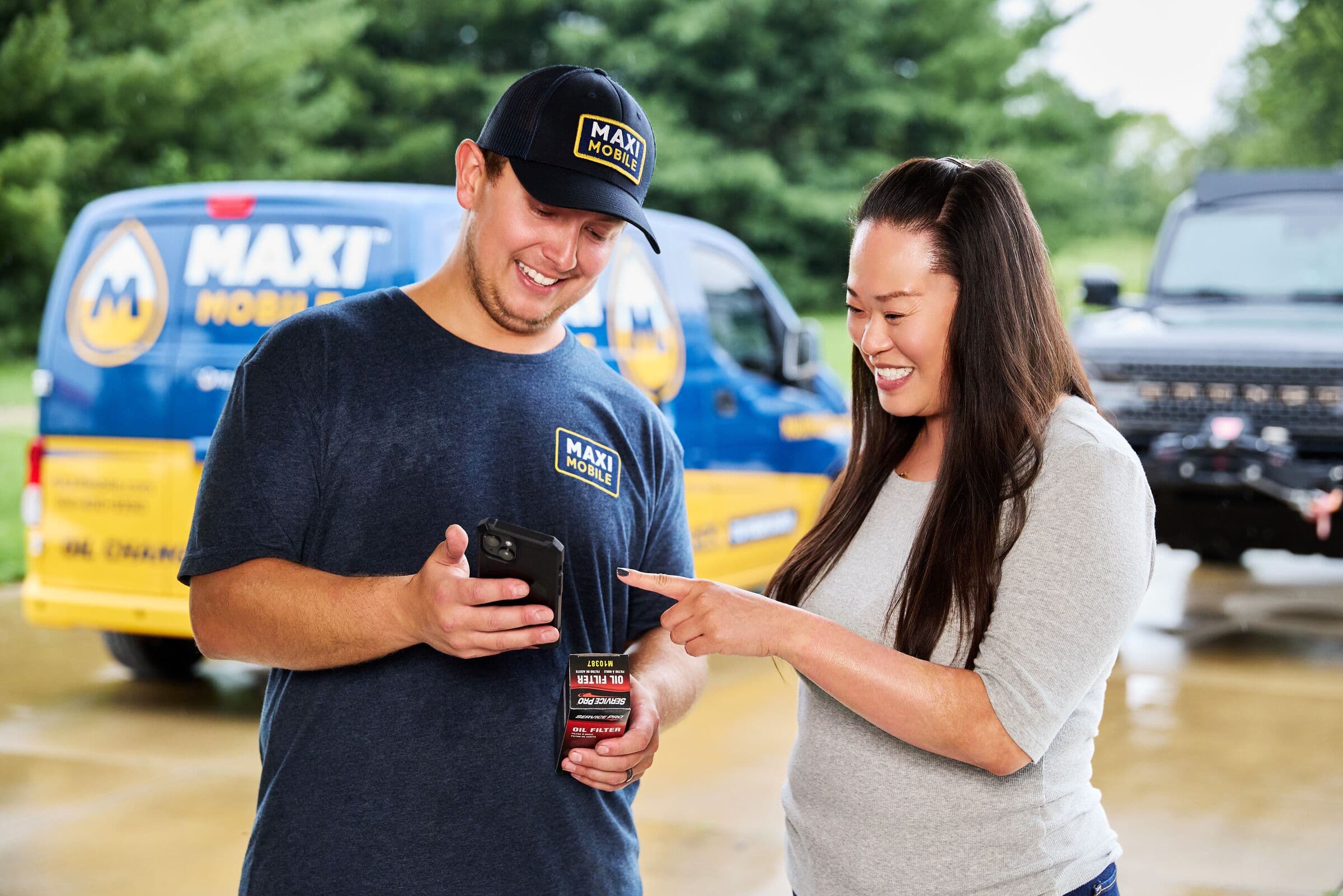 A MAXI technician walking a customer through her service on his phone