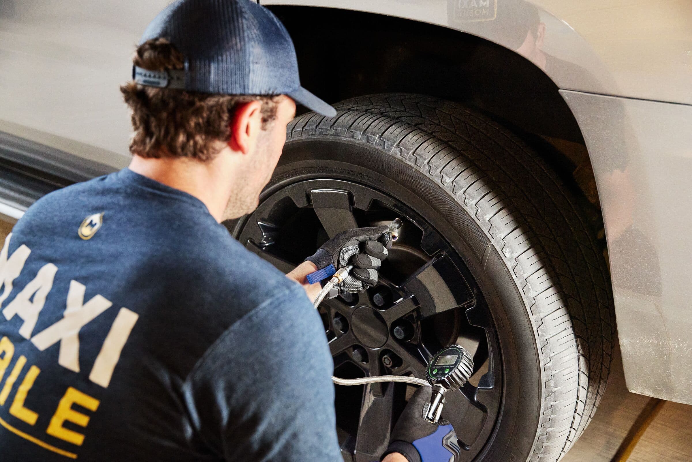 A MAXI technician torquing the lug nuts on a customer's wheel