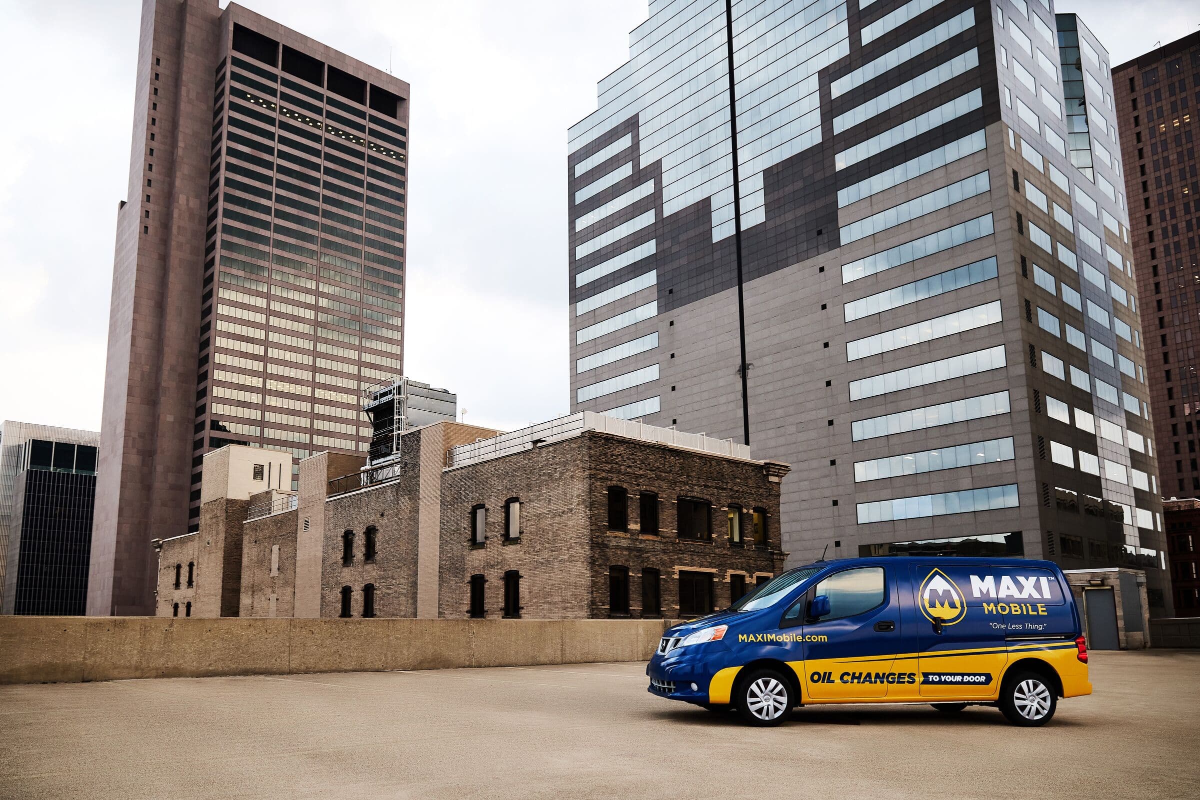 A MAXI Mobile service van parked on a downtown rooftop between city towers