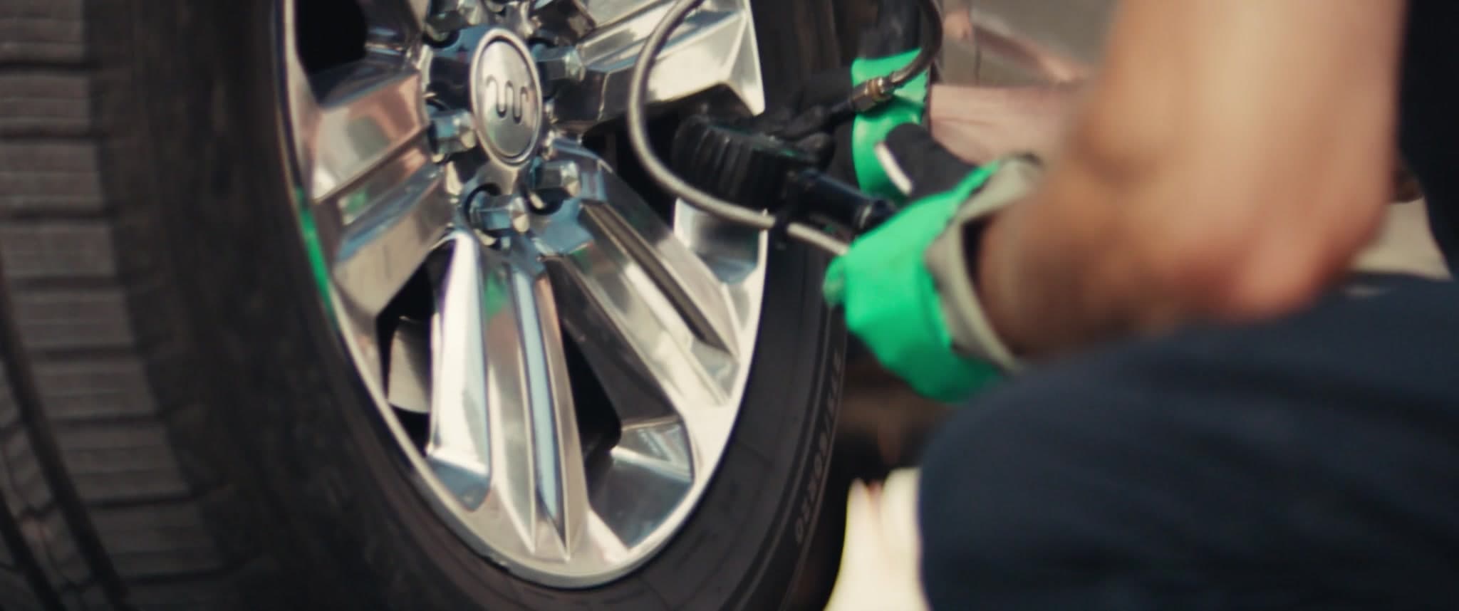 MAXI technician servicing a tire in a customer's driveway