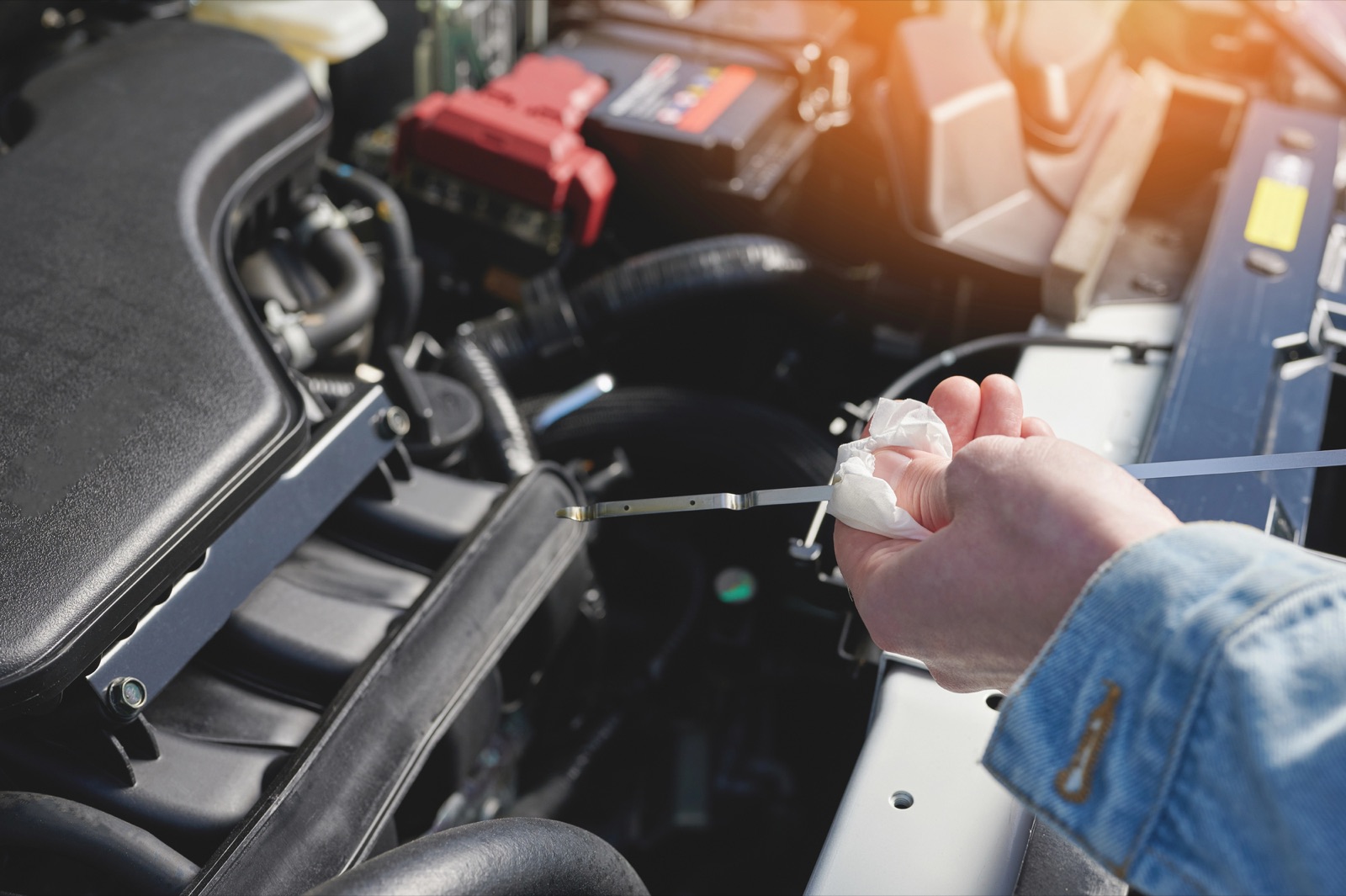 Checking the engine oil level with a dipstick under the hood