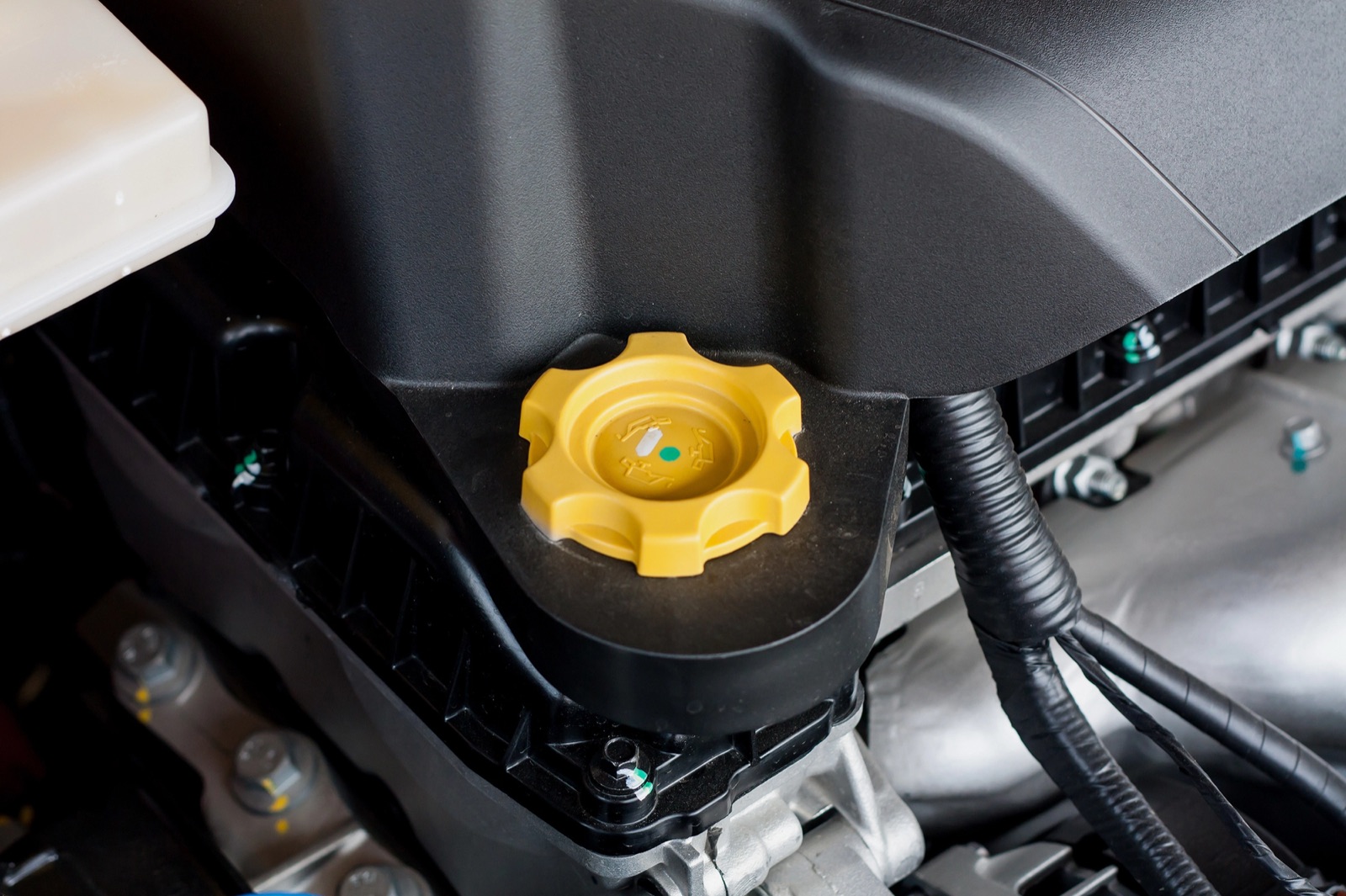 Yellow oil filler cap on a modern engine