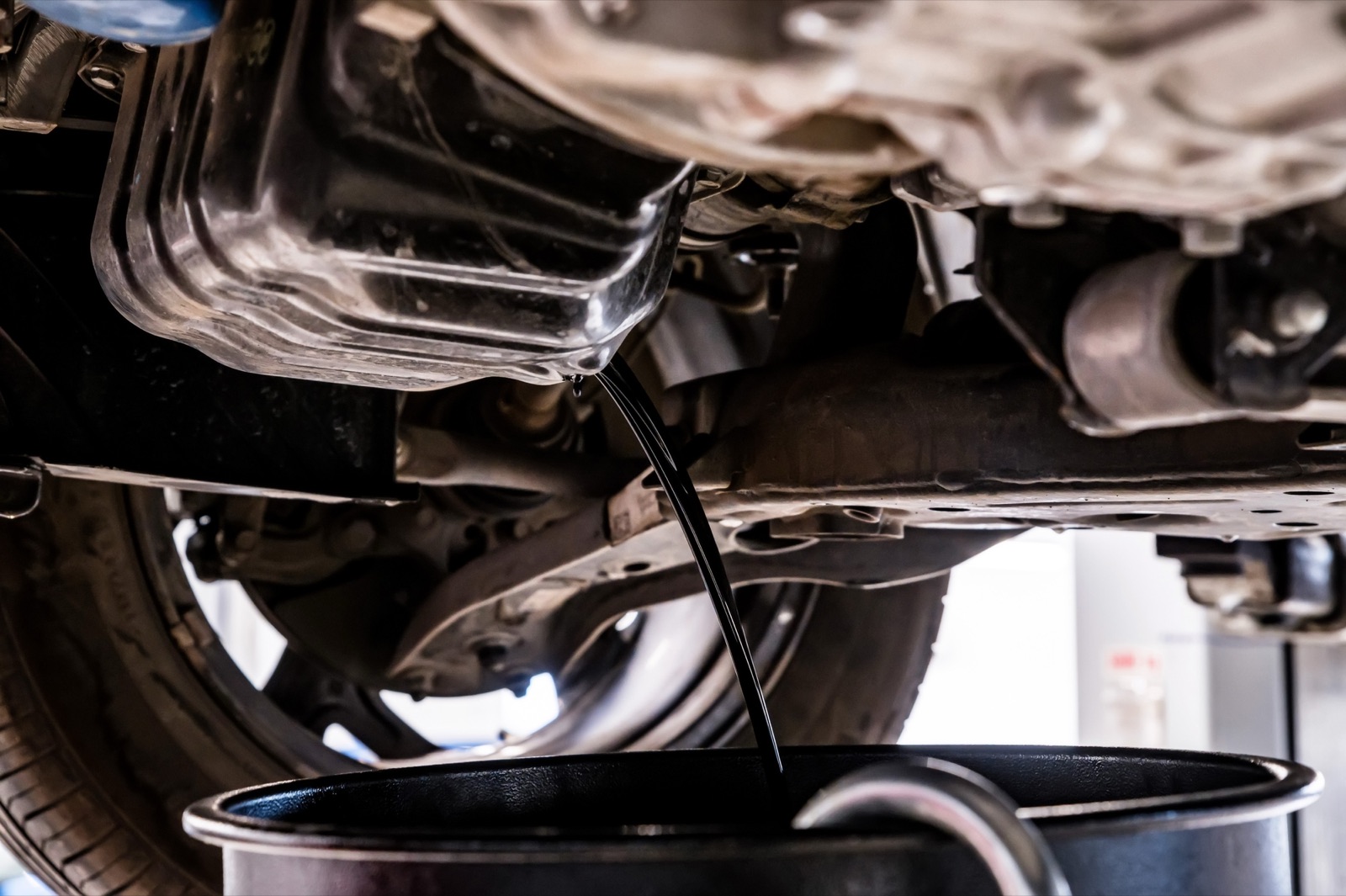 Used oil draining from the oil pan during an oil change
